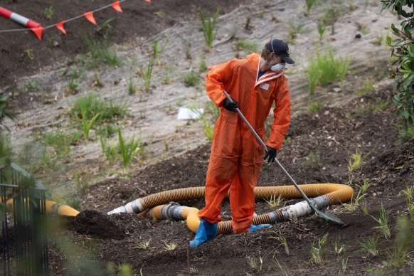 A worker removes mulch at Rozelle Parklands, which was closed in 2024 after asbestos was found in several areas.