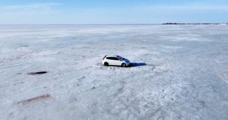 Abandoned car retrieved from ice off Nova Scotia shore by helicopter, snowmobiles