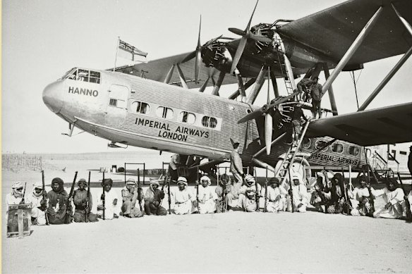 An Imperial Airways plane surrounded by an armed guard from the Sheikh of Sharjah during a refuelling stop at Sharjah Airport in the Trucial States in 1934.