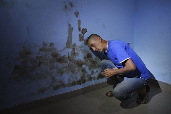 Torture chamber: Olekdsndr Fayizov, a civilian computer technician, demonstrates where Russian soldiers beat his head against the wall of a room used as a cell in the basement of the Trostyanets railway station in Ukraine in June 2022.