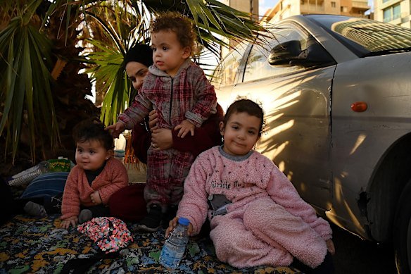 Zainab al Mawla and her children – Alaa, 11 months, Ali, 2, and Baloul, 4 – smile and play on the rug that is now their temporary home on March 6.