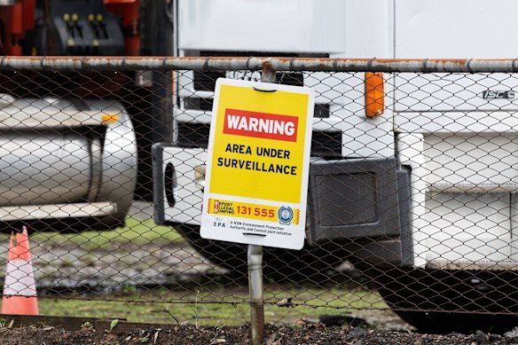 Signage pinned to the fence of the property warns against illegal dumping.