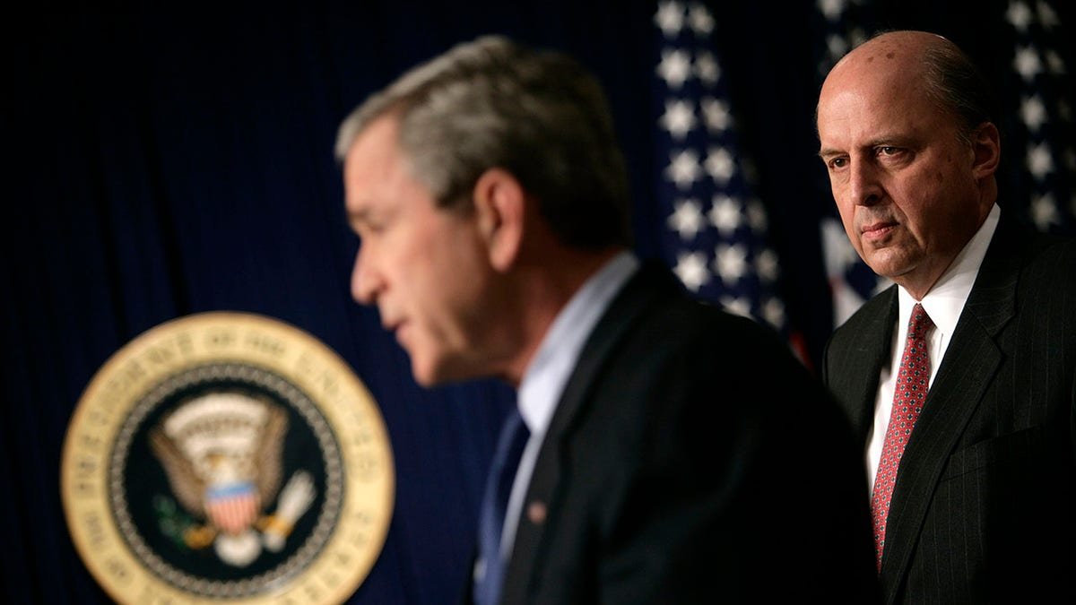 John Negroponte looks on while President Bush holds press conference