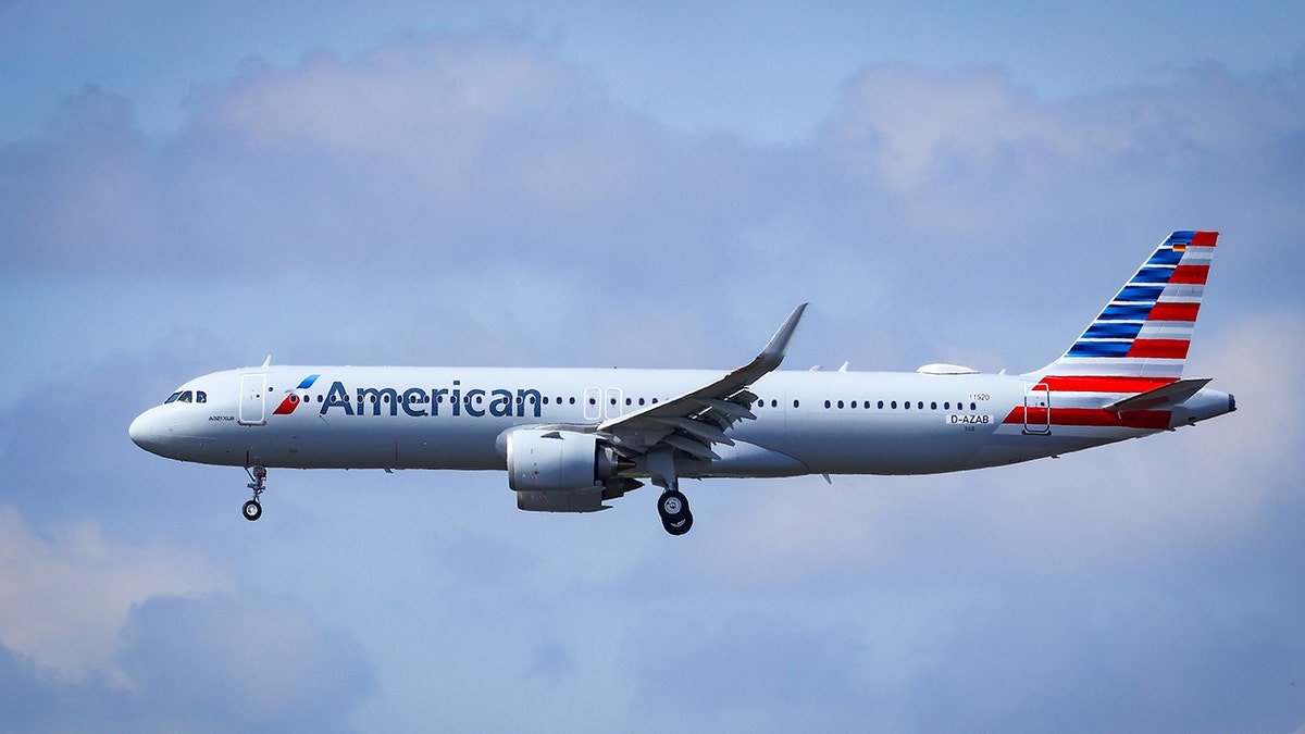 American Airlines Airbus passenger jet in flight against a blue sky.