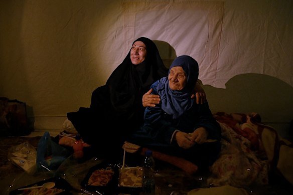 Zahra Issa with her mother, Um Ahmad, during Iftar inside their tent at the al Zarif Intermediate School on March 7. The school is now a shelter for more than 1000 displaced people in West Beirut who have fled Bint Jbeil in southern Lebanon because of Israeli airstrikes.