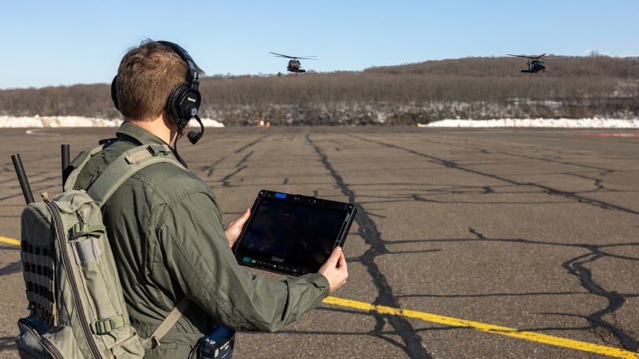 Army operator using tablet to control autonomous Black Hawk helicopters during test