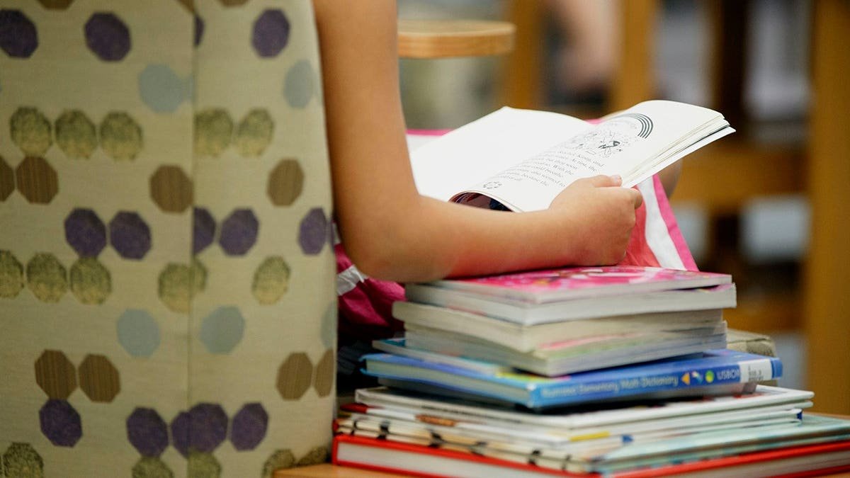 child's hands holding book