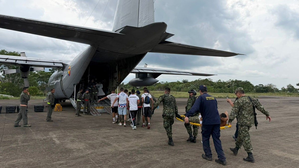 Injured people are loaded onto a plane on stretchers.