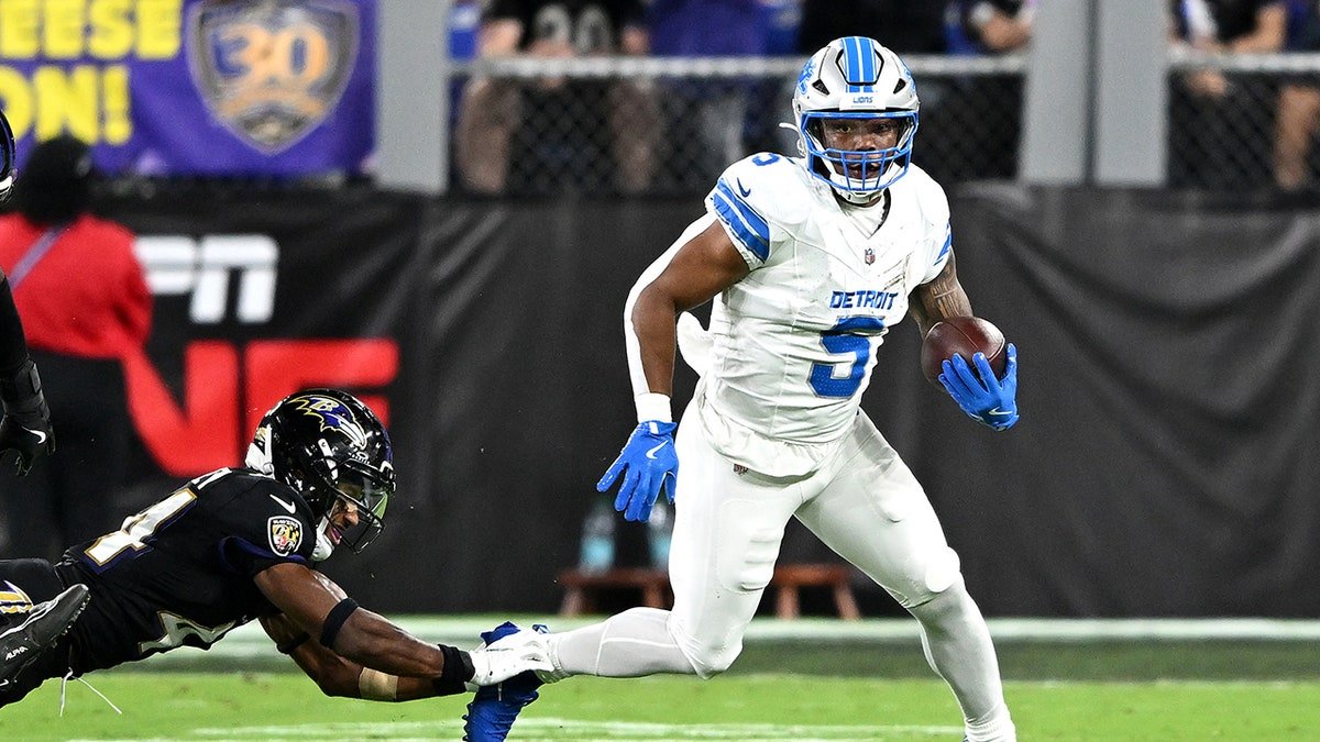 David Montgomery runs with football