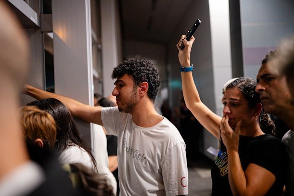 Supporters watch as the Iranian women’s soccer team arrive at Sydney International Airport, before the players depart for Iran.