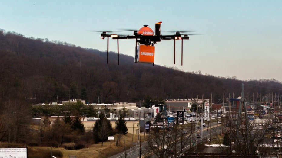 drone with grubhub logo flies alonside hill