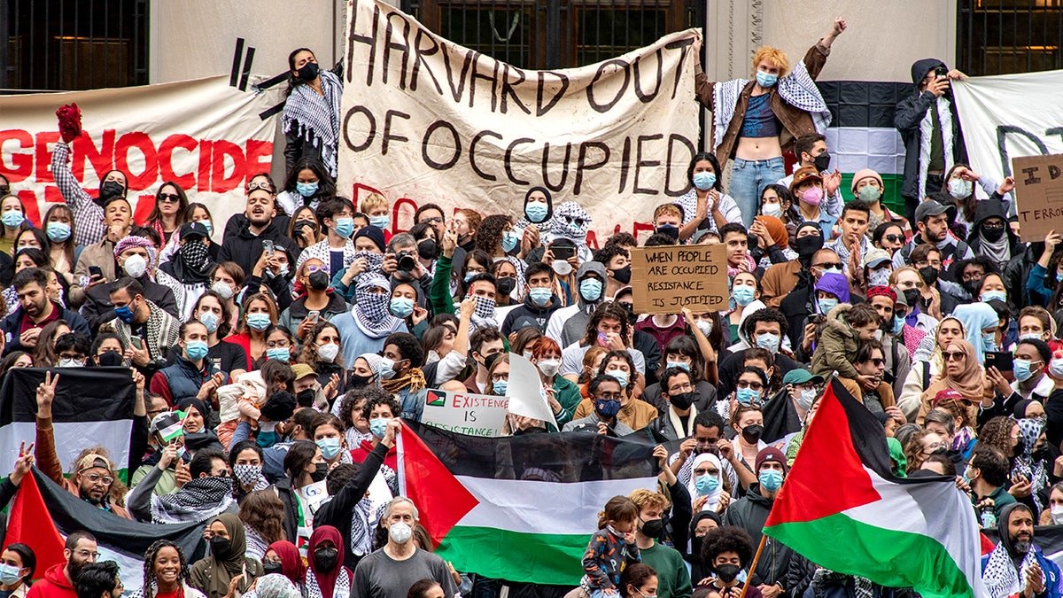 Supporters of Palestine gather at Harvard University, holding signs and listening to speakers during a pro-Palestinian rally on campus.