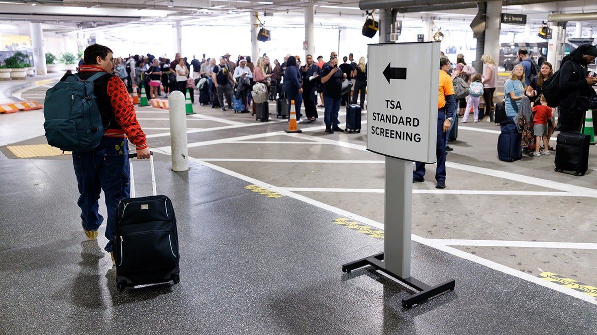 Travelers wait in line at a Transportation Security Administration (TSA) checkpoint at William P. Hobby Airport in Houston, Texas, US, on Monday, March 9, 2026. Airports in the US are reporting longer-than-normal wait times in security lines, as Transportation Security Administration agents are poised to miss their first full paycheck this week. Photographer: Mark Felix/Bloomberg via Getty Images