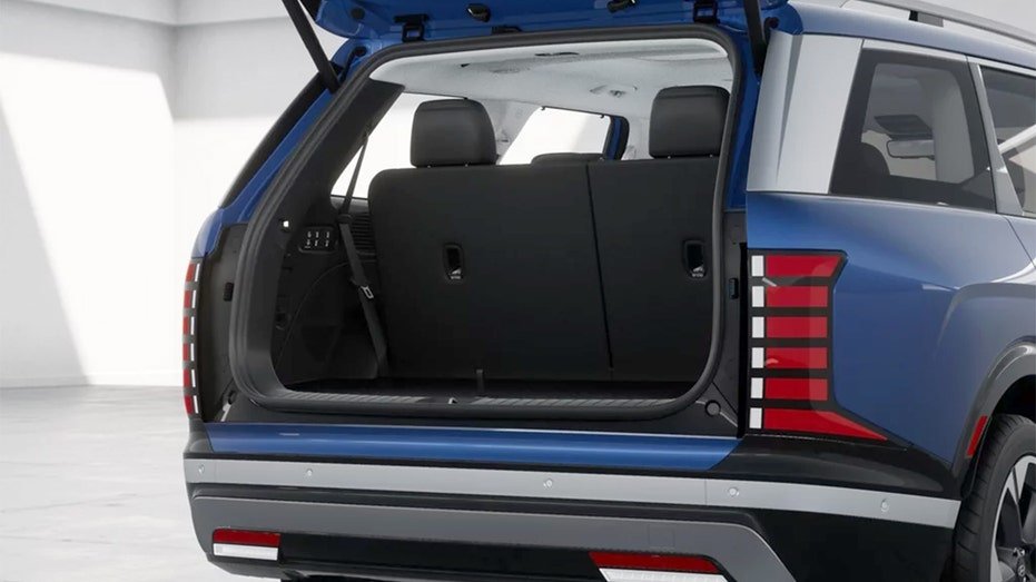 A blue Hyundai Palisade with an open liftgate showing the rear cargo area and third-row seats.