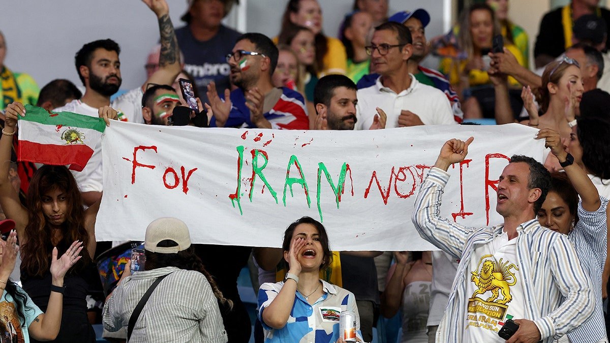 Iranian supporters hold a banner