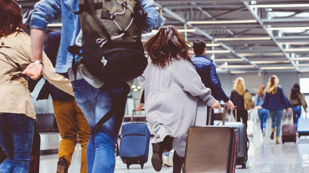 people in airport with luggage