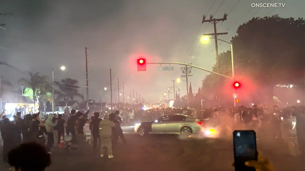 silver care doing donuts in intersection during street takeover