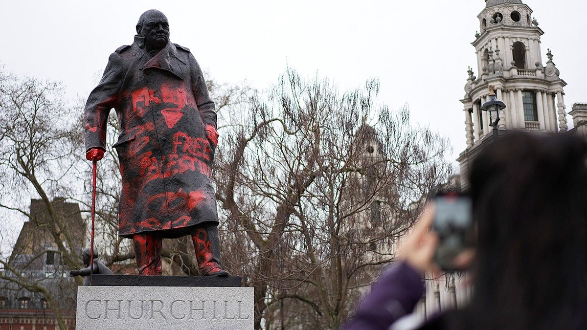 A statue of Winston Churchill covered in graffiti