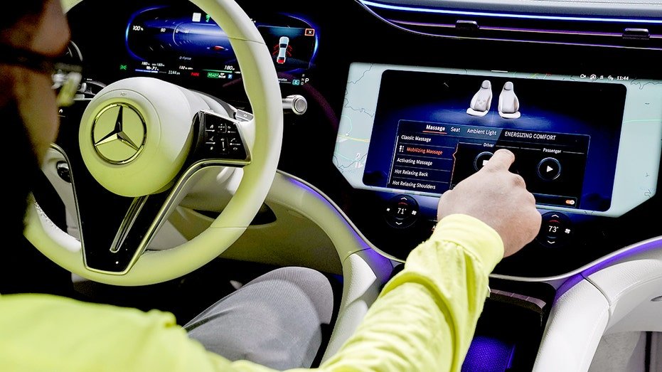 A person sits inside a Mercedes-Benz EQS.