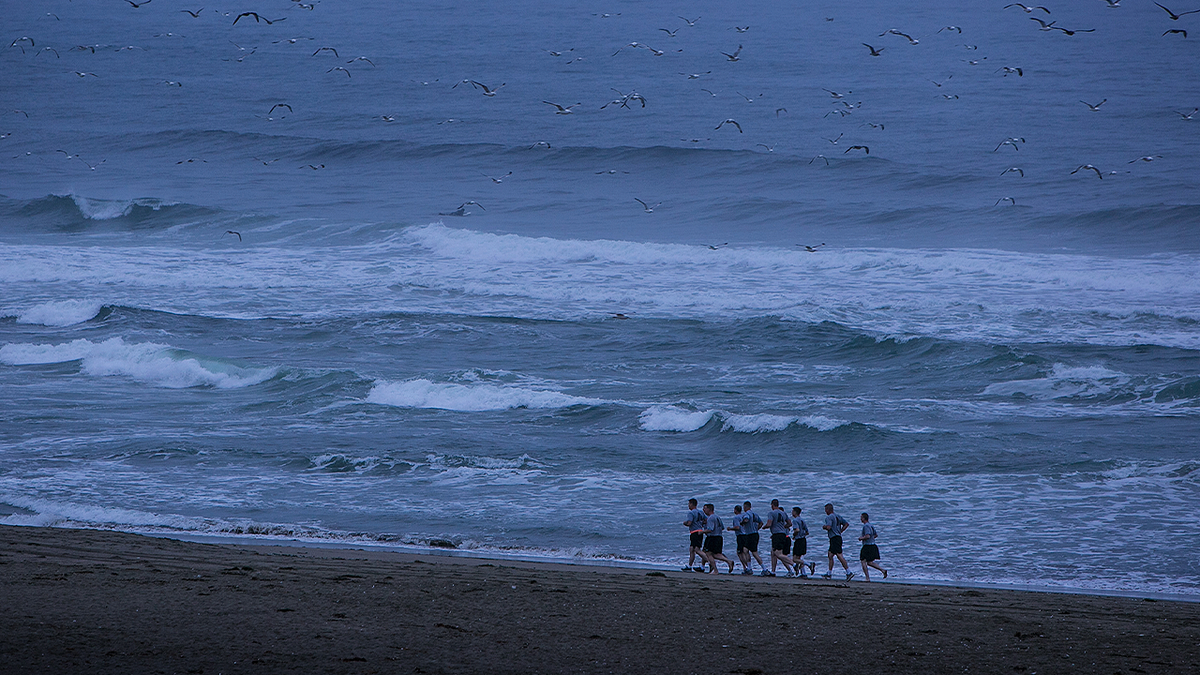 Coast Guard cadets run along Salmon Creek Beach in Bodega Bay, California