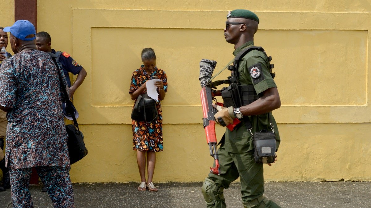 Police officer moves through a crowd gathered on a city street during a public demonstration.