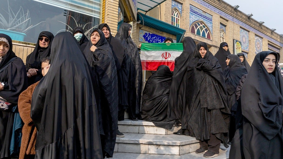A woman holds an Iranian flag during a funeral ceremony at the Imamzadeh Saleh shrine in Tehran.