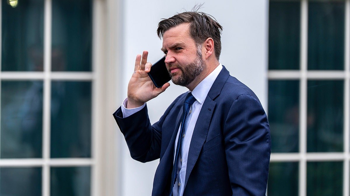 Vice President JD Vance talking on a cell phone while walking toward the West Wing.