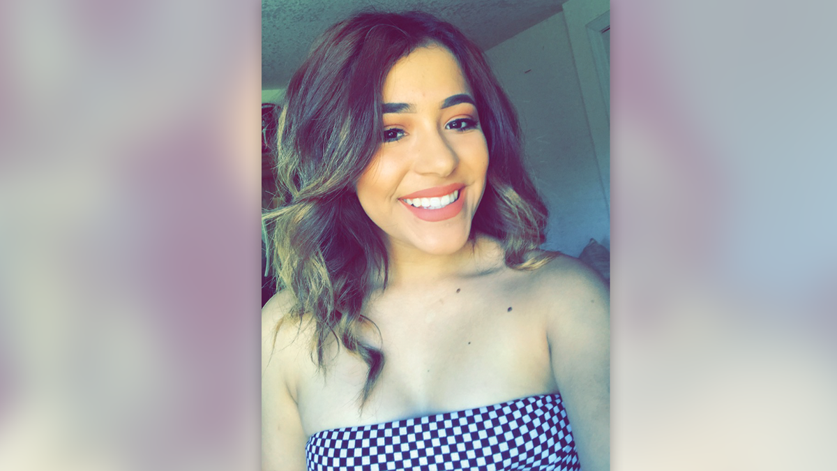 Victoria Marquine smiles with brown hair and blonde highlights wearing a checkered top