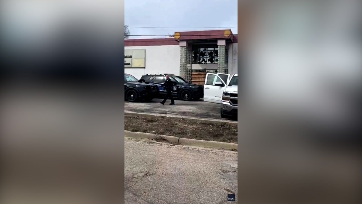 police approach patrol vehicle