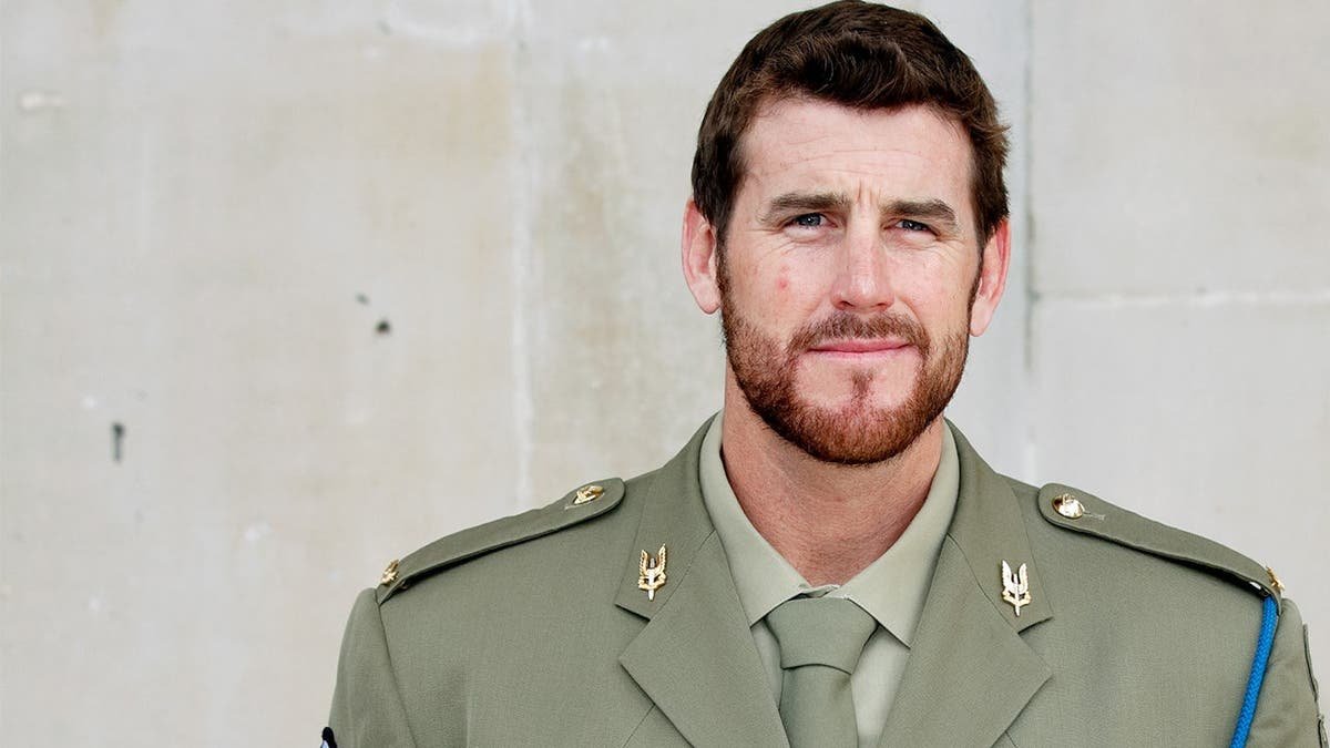 Ben Roberts-Smith standing outside St. Martin-in-the-Fields Church while wearing a suit and medals.