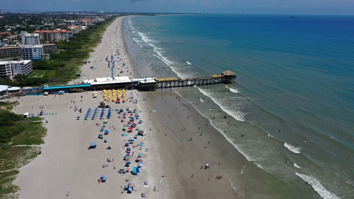 Aerial view of beachgoers near the pier at Cocoa Beach Florida