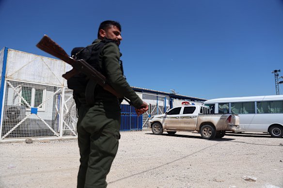 A soldier stands guard as vehicles arrive at al-Roj Camp in eastern Syria to transport Australian families to Damascus as part of a second repatriation effort.