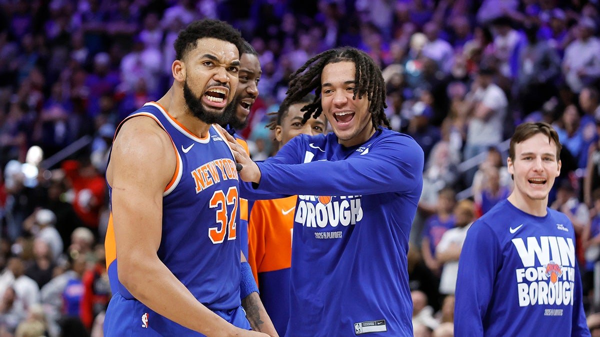 New York Knicks guard Pacome Dadiet celebrating with center Karl-Anthony Towns on basketball court
