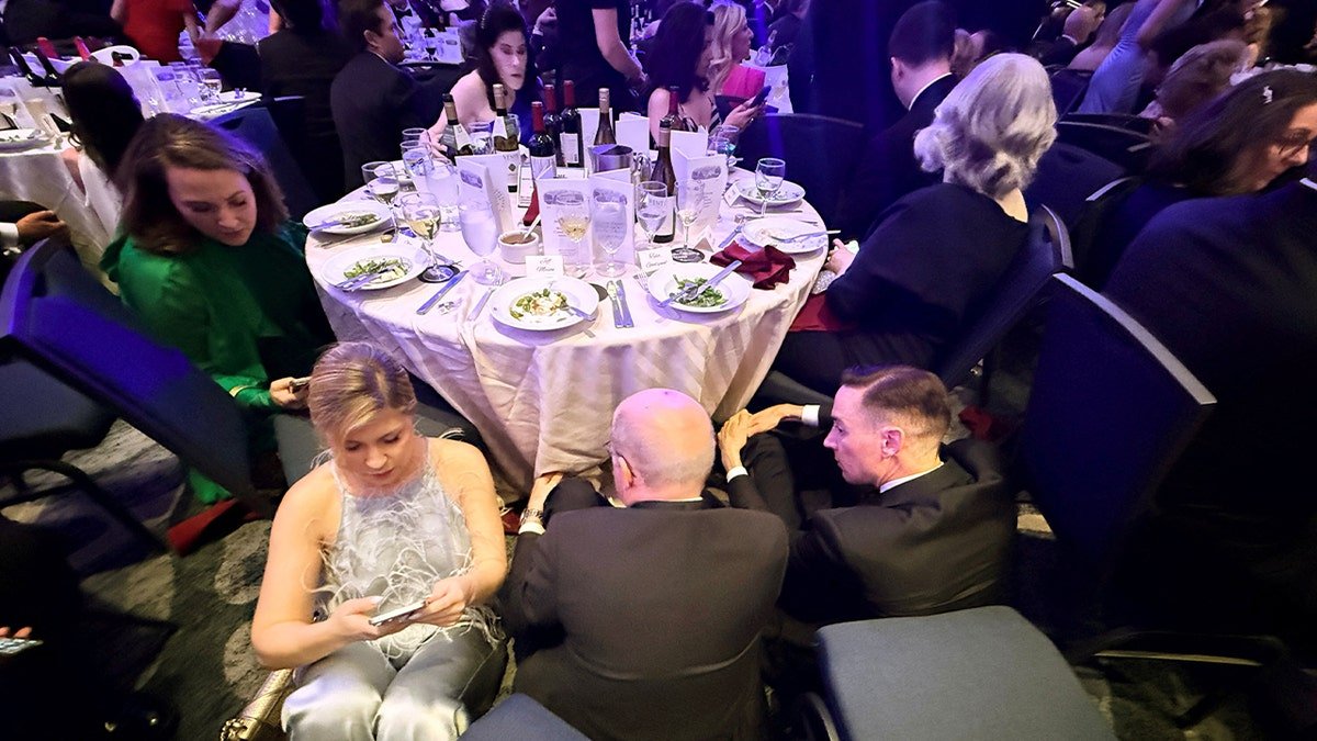 Attendees ducking under tables at the White House Correspondents' Dinner.