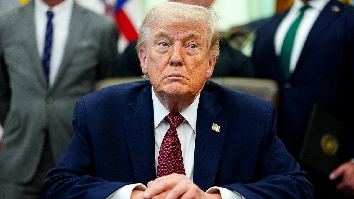President Donald Trump sits at the Resolute Desk in the Oval Office