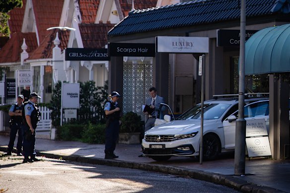 Police gather outside the luxury consignment store on Thursday. 