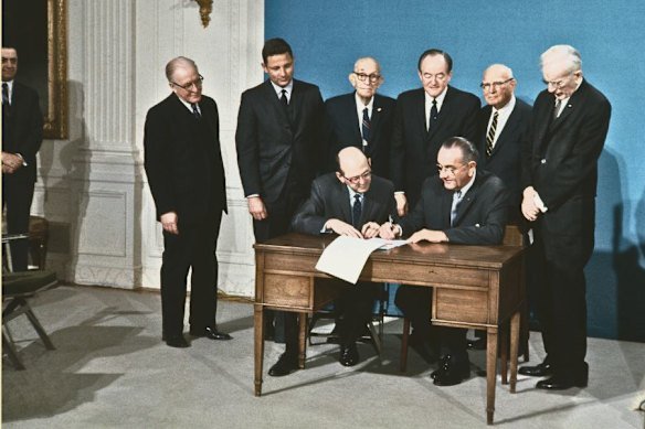 President Lyndon Johnson, seated right, signs the 25th Amendment to the US Constitution in Washington DC on February 23, 1967. Among those with him are Birch Bayh (standing second from left) and Emanuel Celler (second from right).