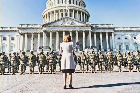 A week after the January 2021 insurrection at the US Capitol, then-speaker of the House, Nancy Pelosi, greets National Guard troops in the newly fenced Capitol Complex.  
