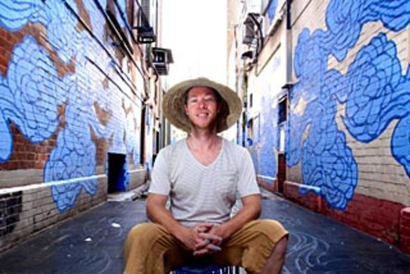 Artist Jason Wing in Kimber Lane in Chinatown with his street artwork titled “In Between Two Worlds”.