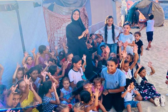 Asmahan Abdalraheem, pictured wearing black, fled her home and lives in a tent.