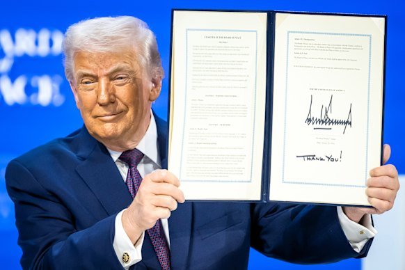 US President Donald Trump holds up a signed charter for the Board of Peace in January.