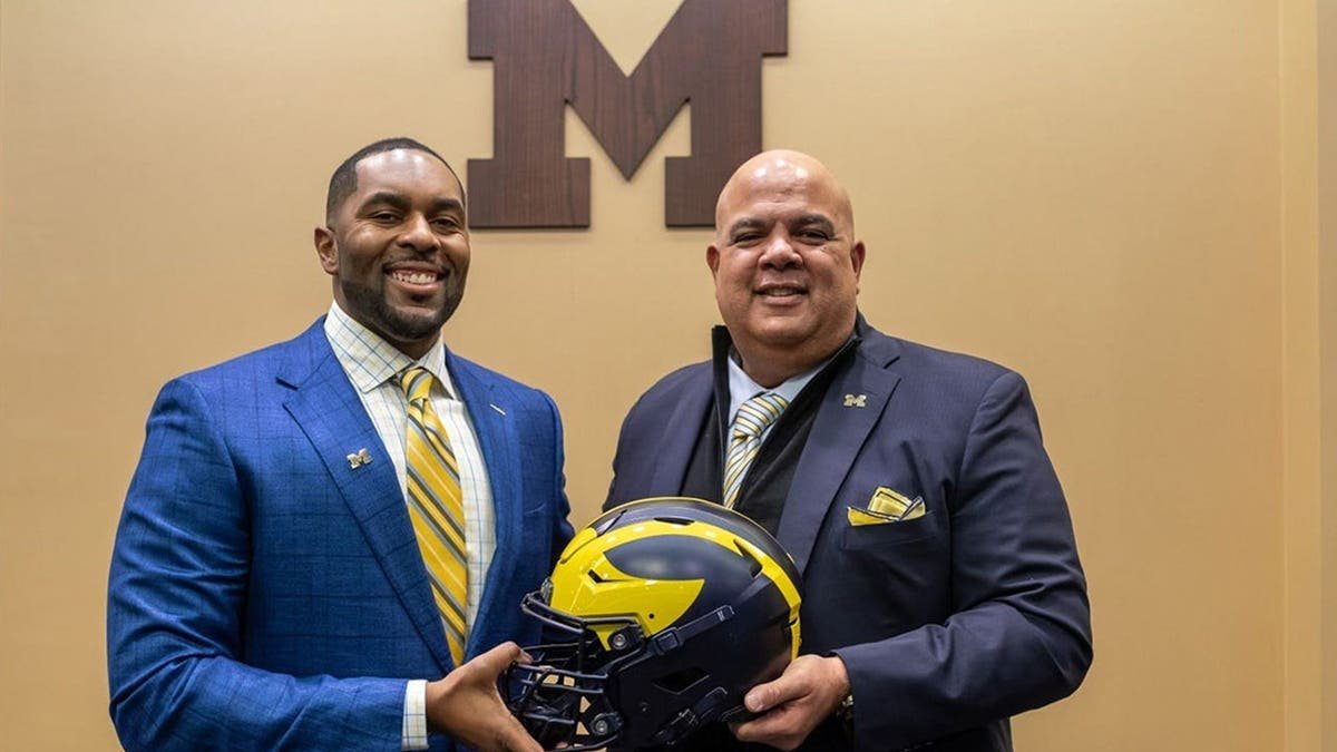 Sherrone Moore stands next to Warde Manuel