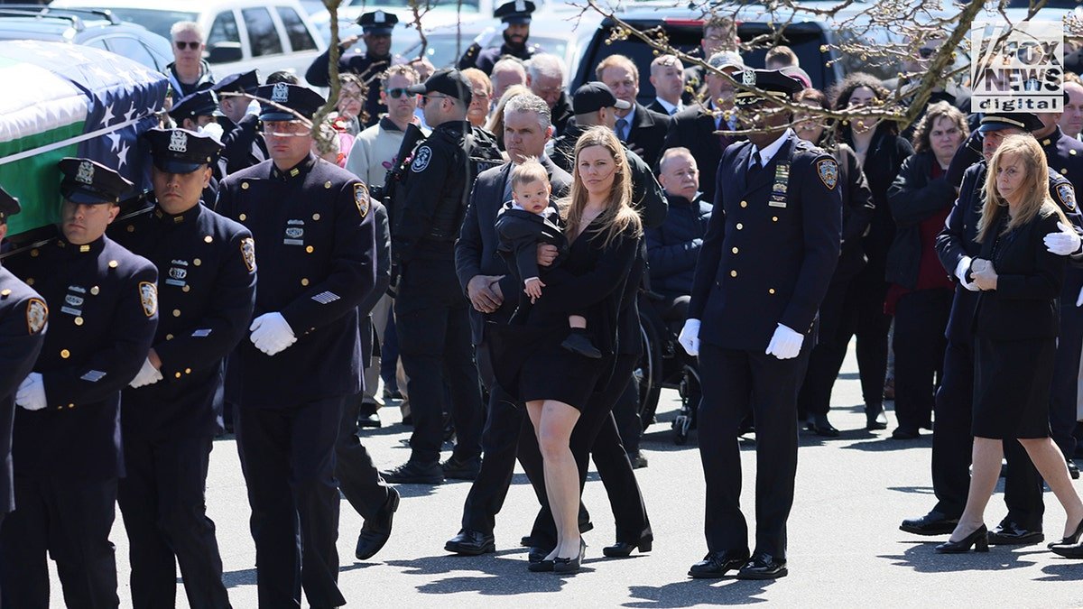 Widow Stephanie Diller and son Ryan Diller seated at funeral service for NYPD Officer Jonathan Diller