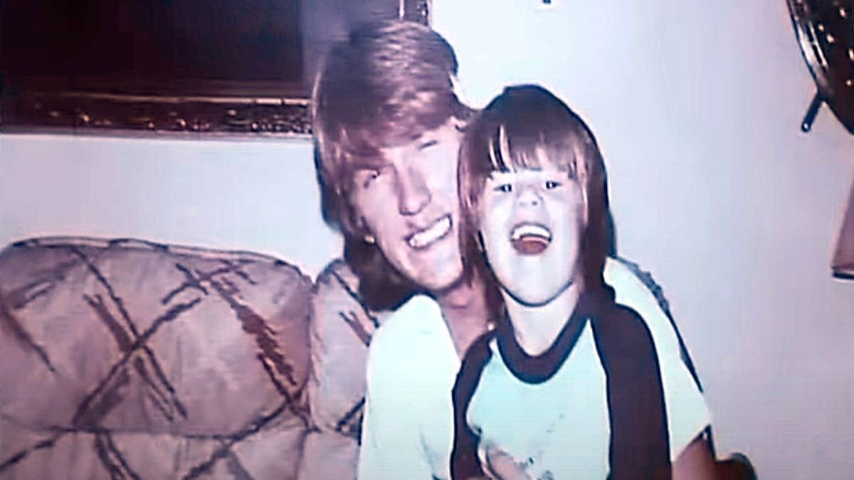 An old photograph of a smiling Timothy Jones Sr. holding his laughing son Timothy Jones Jr.