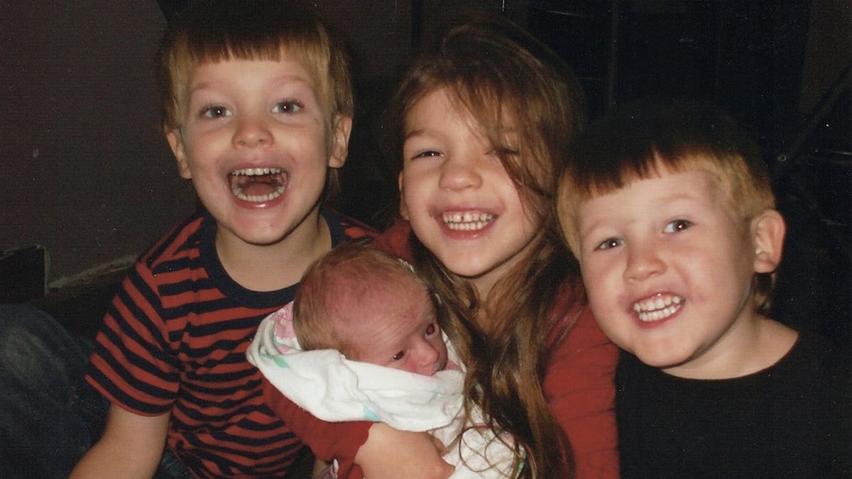 Four of Timothy Jones Jr.'s children smiling and huddling together.