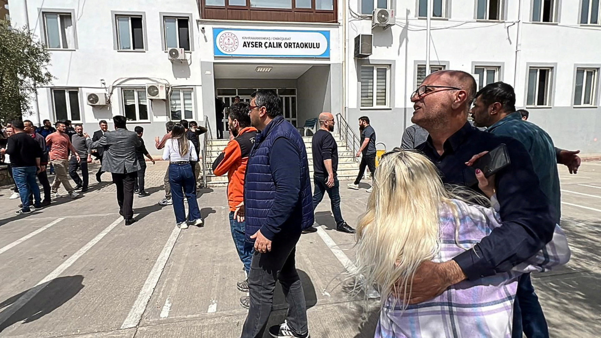 People wait in front of the school building after a deadly shooting in Turkey
