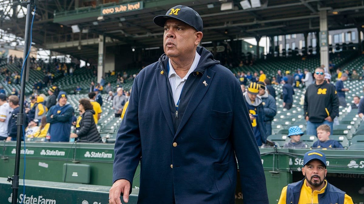 Athletic Director Warde Manuel walking onto football field