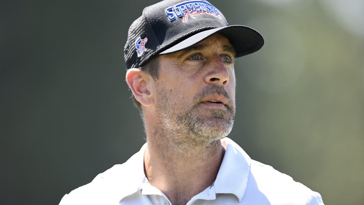 Aaron Rodgers looks on during a golf event