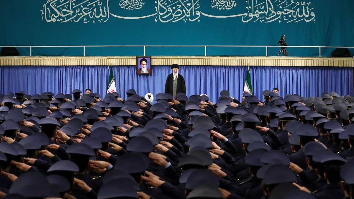 Supreme Leader Ayatollah Ali Khamenei standing as air force commanders salute in Tehran