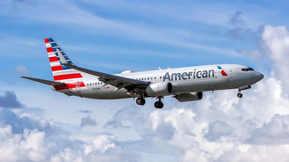 American Airlines Boeing 737-800 airplane flying in partly cloudy blue sky